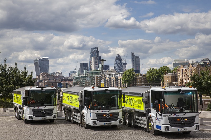 Three HGVs in front of the London skyline